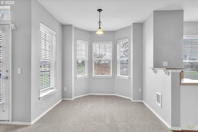 unfurnished dining area featuring carpet flooring, baseboards, and visible vents