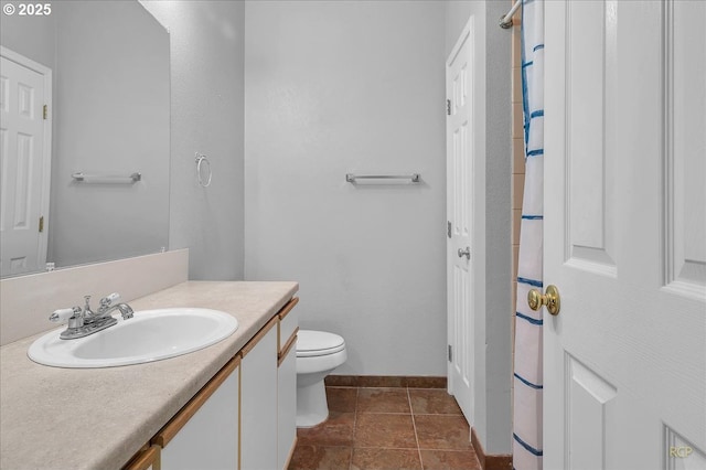 full bath with baseboards, toilet, vanity, and tile patterned flooring