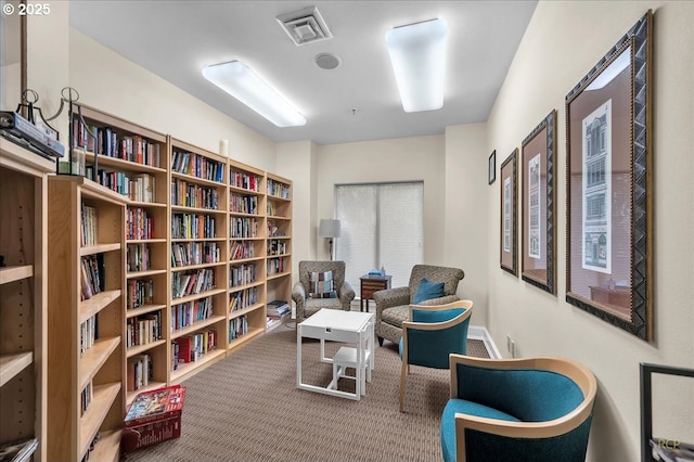 living area with visible vents and carpet