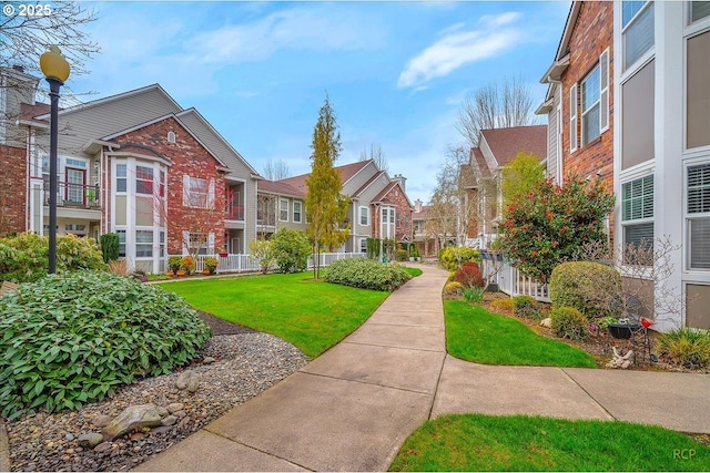 view of community with a yard, a residential view, and fence