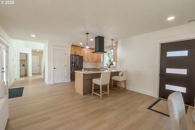 535 E St, Independence, OR 97351 - kitchen with stainless steel refrigerator with ice dispenser, island exhaust hood, light brown cabinets, light wood-type flooring, and a peninsula