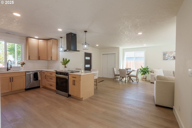 535 E St, Independence, OR 97351 - kitchen with stainless steel appliances, wall chimney range hood, light brown cabinets, recessed lighting, and a textured ceiling