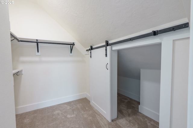 535 E St, Independence, OR 97351 - spacious closet with a barn door, carpet flooring, and lofted ceiling