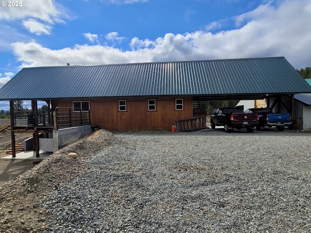 exterior space featuring a carport, metal roof, and gravel driveway