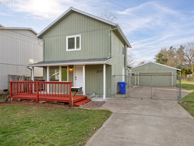 view of front of house with a porch, an outbuilding, a front lawn, and a garage