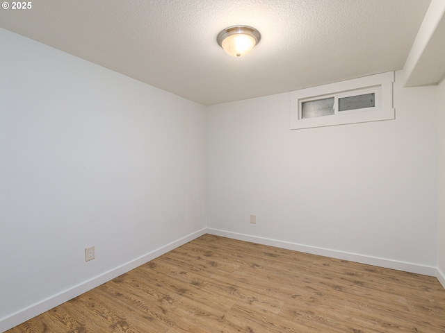 unfurnished room with a textured ceiling and light hardwood / wood-style flooring