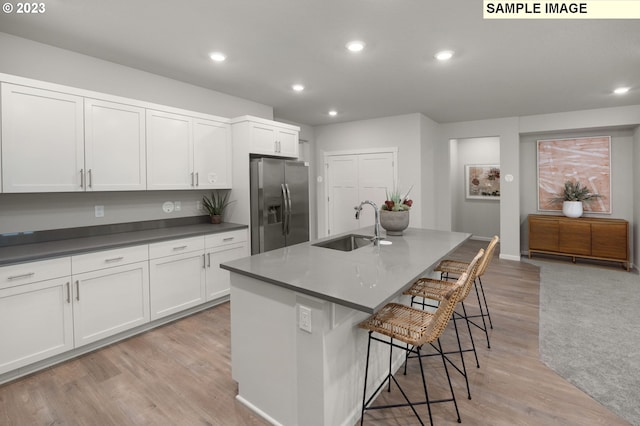 2484 SE Teal Ave, Gresham, OR 97080 - kitchen featuring stainless steel fridge, recessed lighting, light wood-style floors, white cabinets, and a breakfast bar