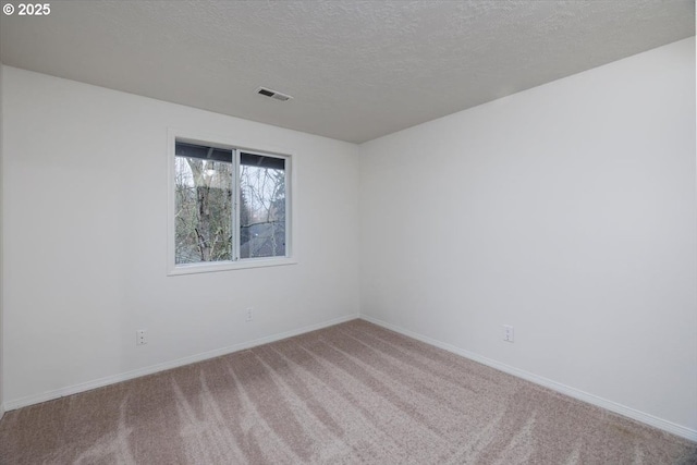 carpeted spare room with a textured ceiling