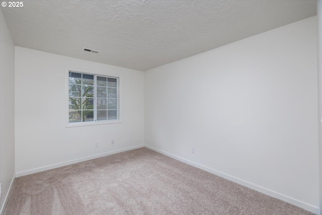 carpeted spare room with a textured ceiling