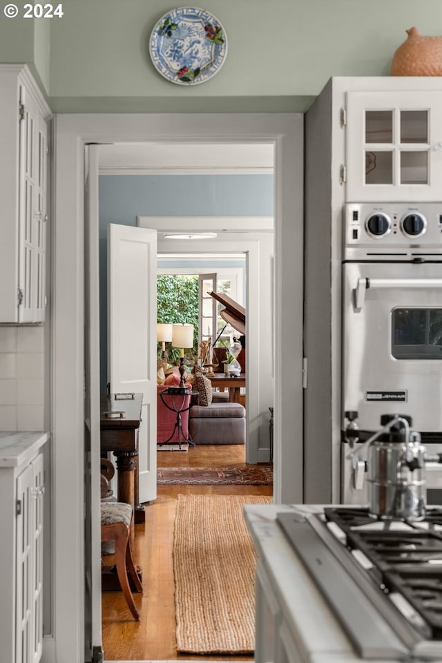 kitchen with appliances with stainless steel finishes, light wood finished floors, and white cabinetry