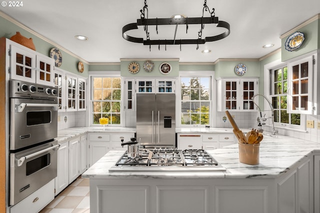 kitchen featuring appliances with stainless steel finishes, crown molding, plenty of natural light, white cabinets, and recessed lighting
