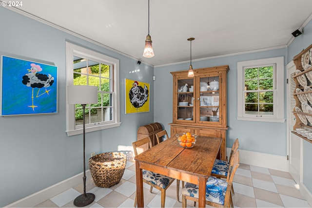 dining area with tile patterned floors, baseboards, healthy amount of natural light, and ornamental molding