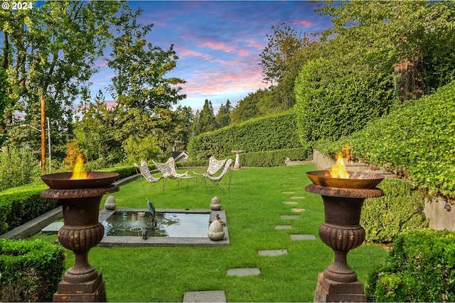 view of community with a fire pit and a yard