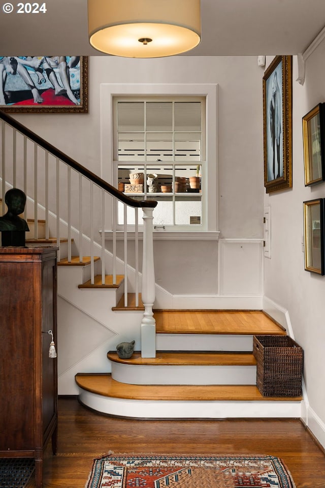staircase with wood finished floors and baseboards