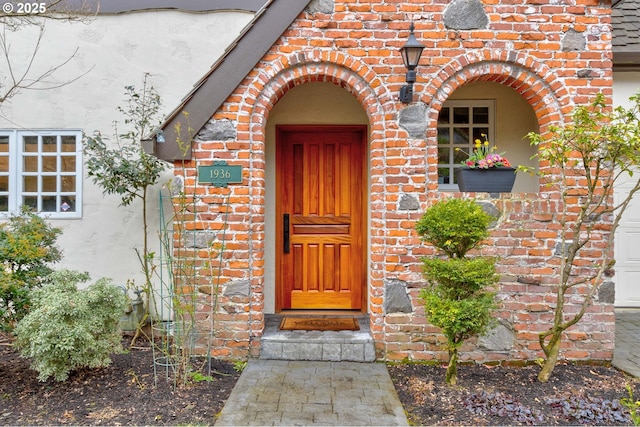 doorway to property with brick siding