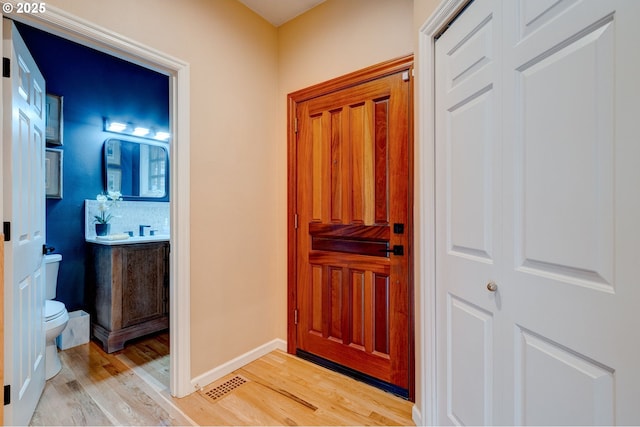 entrance foyer featuring light wood-style flooring, visible vents, and baseboards