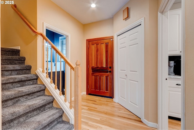 entryway featuring light wood-style floors, recessed lighting, and stairs