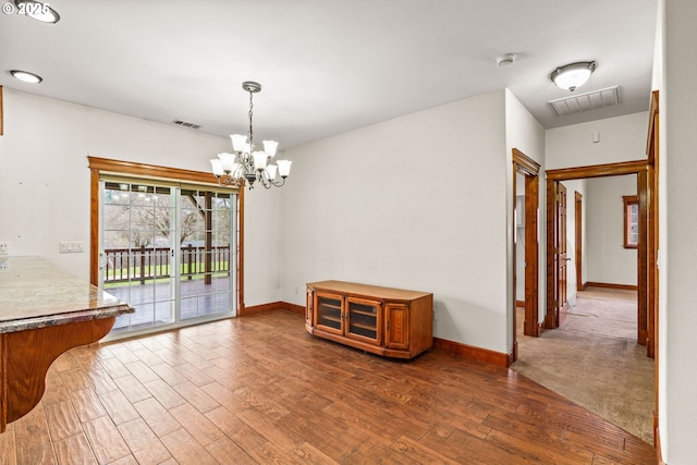 dining area with baseboards, visible vents, and wood finished floors