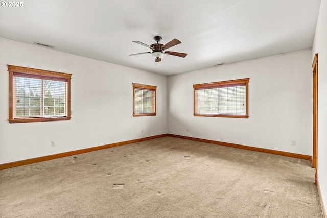 carpeted empty room with baseboards, visible vents, and a healthy amount of sunlight