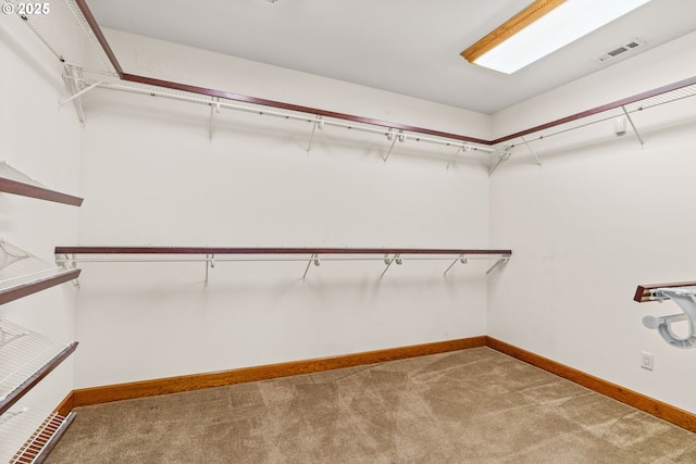 spacious closet featuring visible vents and light colored carpet