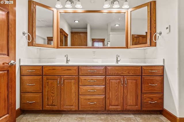 bathroom featuring visible vents, a sink, baseboards, and double vanity