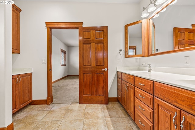 bathroom featuring double vanity, tile patterned flooring, baseboards, and a sink