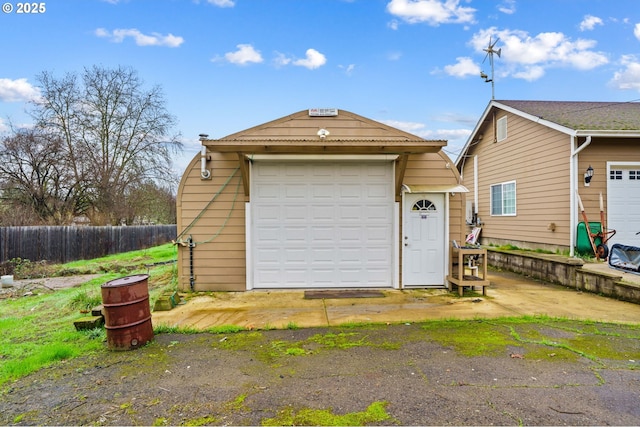 detached garage featuring fence