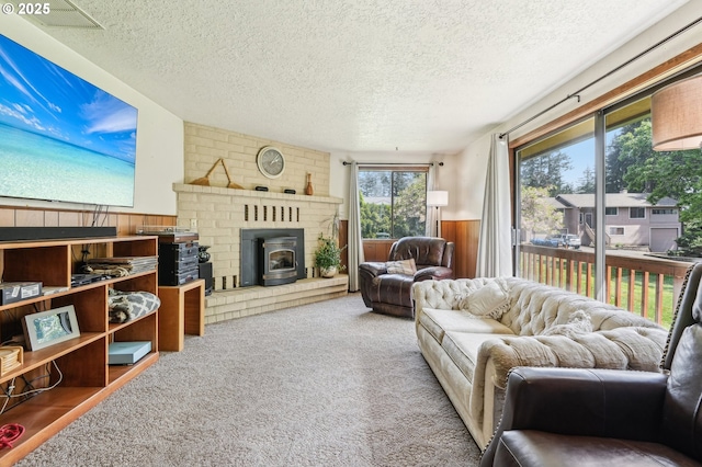 living area with carpet flooring, a textured ceiling, and visible vents