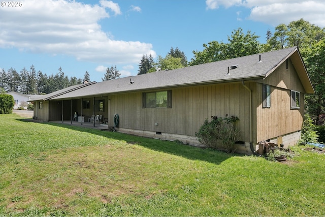 back of property featuring a lawn, crawl space, a shingled roof, and a patio area