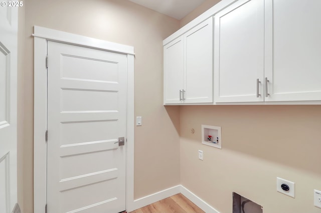 washroom featuring electric dryer hookup, hookup for a washing machine, cabinets, light hardwood / wood-style flooring, and hookup for a gas dryer