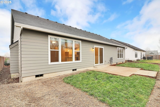 back of property with a patio area and a yard