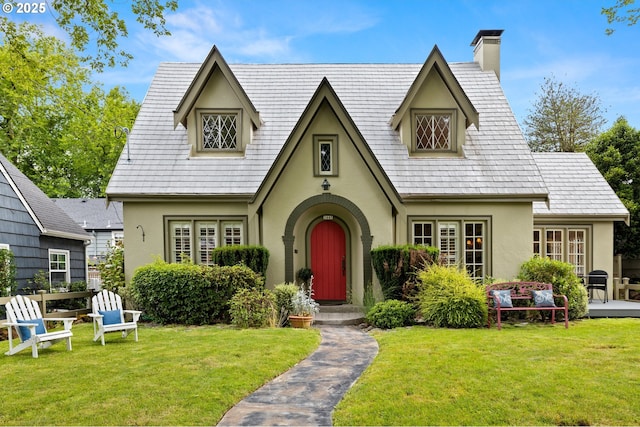 tudor home featuring a front lawn