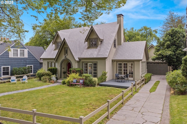 view of front facade with a garage, a front yard, and a deck