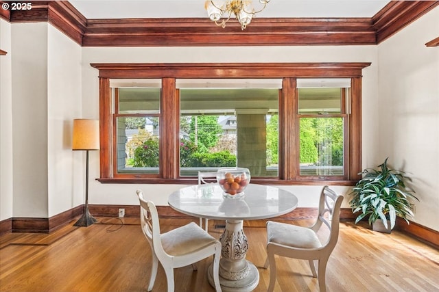 dining space featuring baseboards, plenty of natural light, and wood finished floors