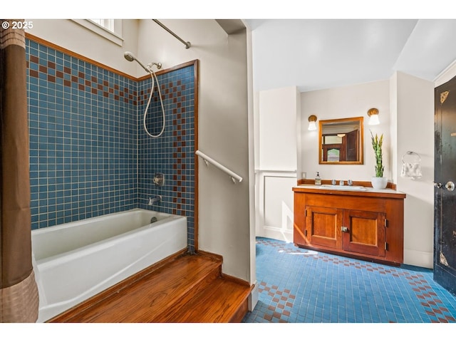 bathroom with baseboards, tub / shower combination, tile patterned flooring, and vanity