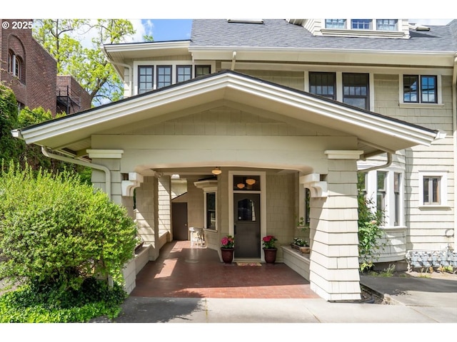 entrance to property with roof with shingles