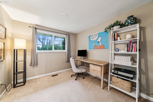 carpeted office space featuring a textured ceiling