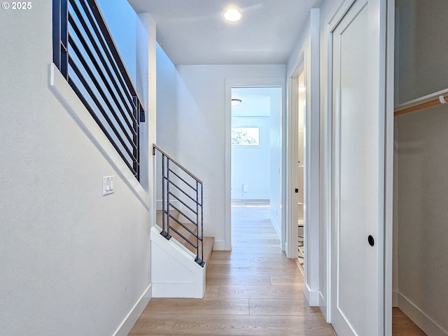 corridor with wood finished floors and baseboards