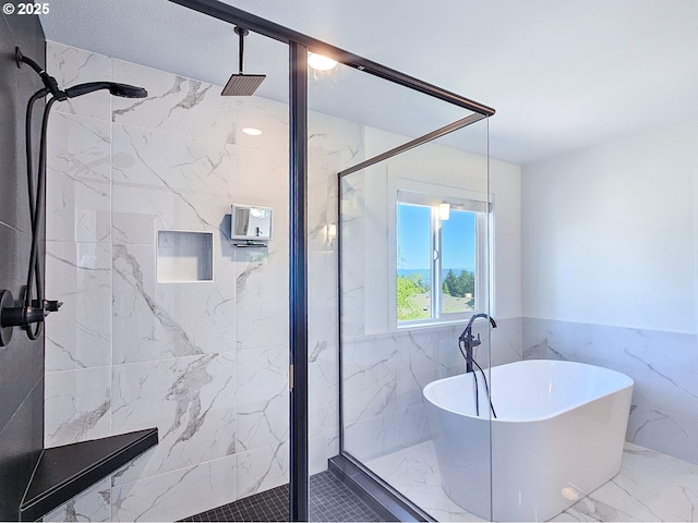 full bath with a marble finish shower, marble finish floors, a freestanding tub, tile walls, and wainscoting