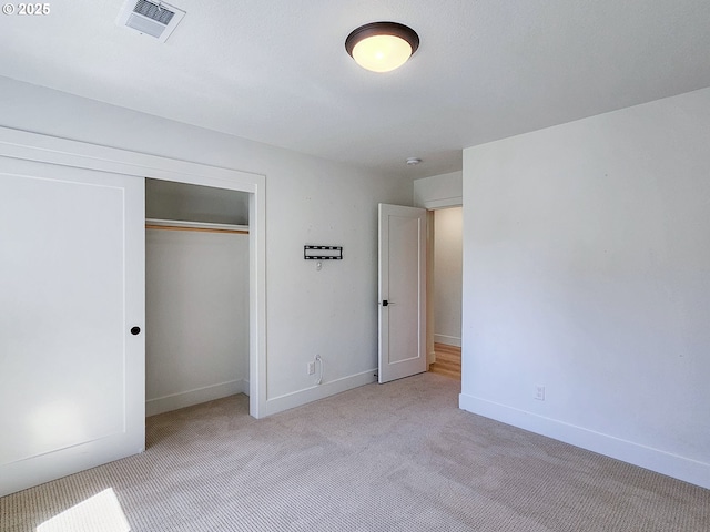 unfurnished bedroom with carpet flooring, baseboards, and a closet