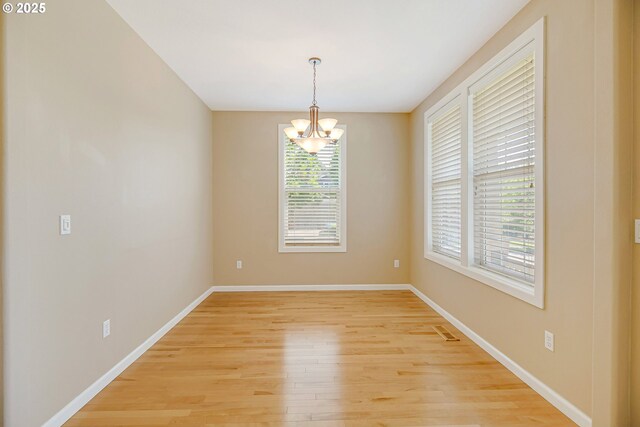 13577 SE Kisor Ct, Happy Valley, OR 97086 - spare room with a chandelier, light wood-style flooring, and baseboards