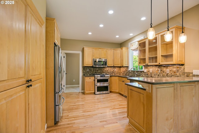 13577 SE Kisor Ct, Happy Valley, OR 97086 - kitchen featuring appliances with stainless steel finishes, light brown cabinetry, a peninsula, a sink, and light wood finished floors