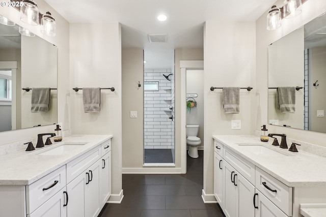 bathroom featuring visible vents, a stall shower, and a sink