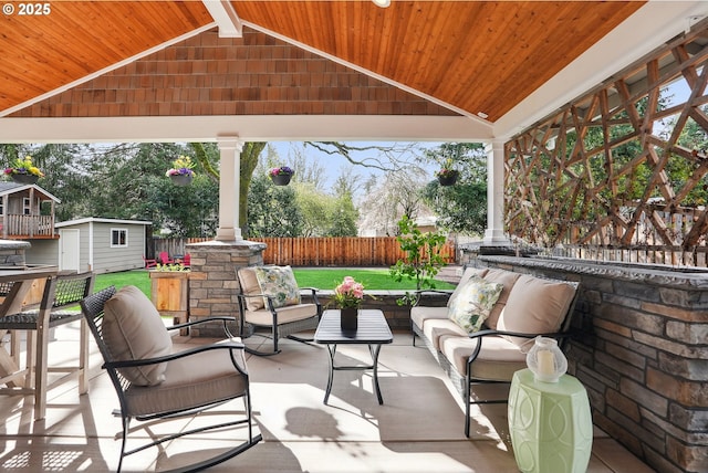 view of patio featuring an outdoor structure, fence, an outdoor living space, and a shed