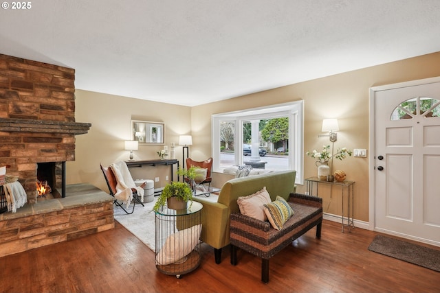 living room featuring a fireplace, wood finished floors, and baseboards