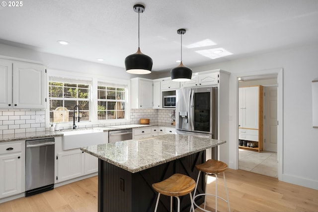 kitchen with a sink, white cabinetry, and appliances with stainless steel finishes