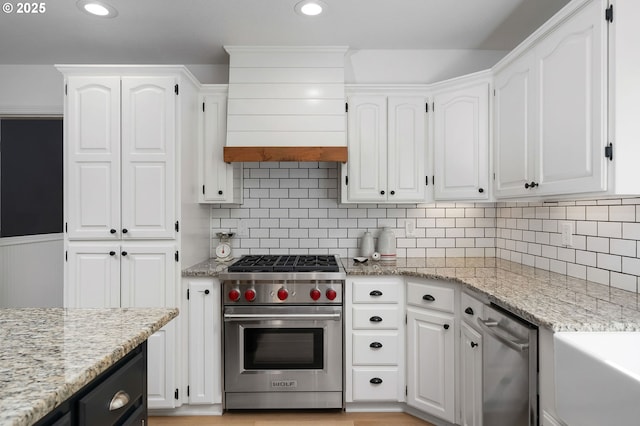 kitchen with white cabinets, appliances with stainless steel finishes, and light stone counters