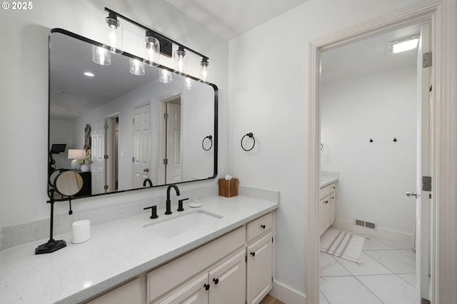 bathroom featuring baseboards, visible vents, marble finish floor, and vanity