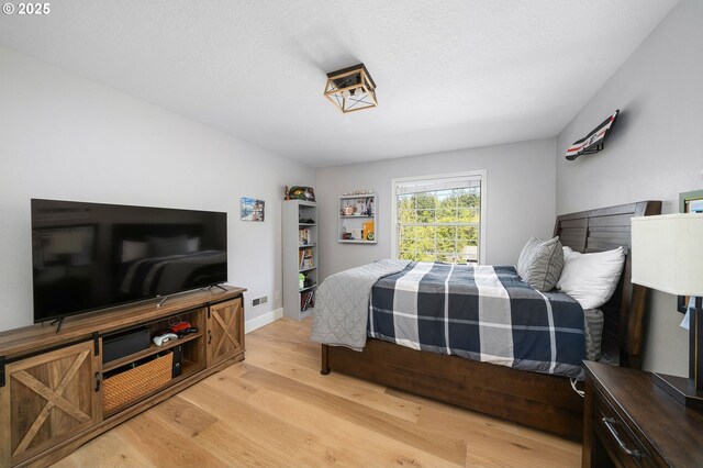 bedroom with light wood finished floors and baseboards