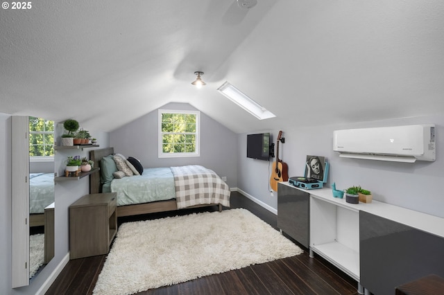 bedroom with baseboards, an AC wall unit, lofted ceiling with skylight, and dark wood-style flooring
